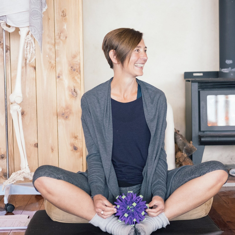 person sitting on pillow in yoga folded leg style